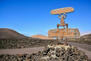 a sign on the side of a road in the middle of a volcanic landscape photo