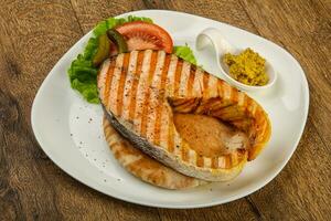 Grilled salmon over wooden background photo