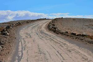 a dirt road in the middle of a desert photo