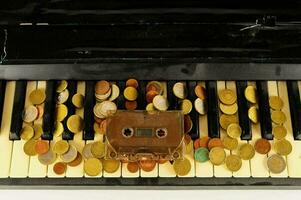 a cassette player and coins on a piano keyboard photo