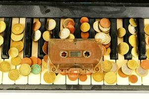 a cassette player and coins on a piano keyboard photo