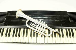 a silver trumpet on top of a piano keyboard photo