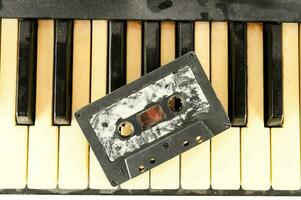 a cassette is sitting on top of a piano keyboard photo