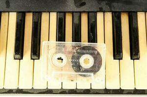 a cassette is sitting on top of a piano keyboard photo