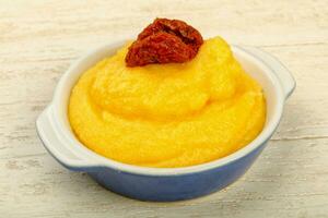 Polenta over wooden background photo