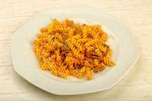 Fussili bolognese over wooden background photo