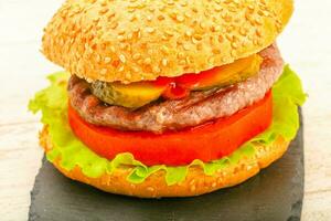 Homemade hamburger over wooden background photo