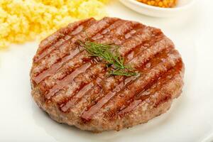 Beef cutlet over wooden background photo