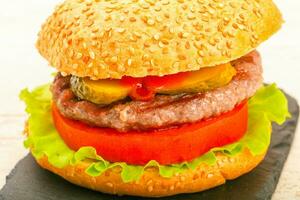 Homemade hamburger over wooden background photo