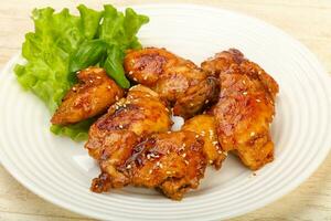 Teriyaki thighs over wooden background photo