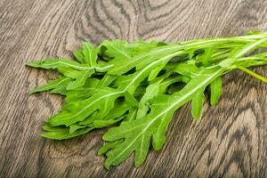Rucola leaves over wooden background photo