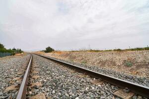 a train track with gravel and trees in the background photo