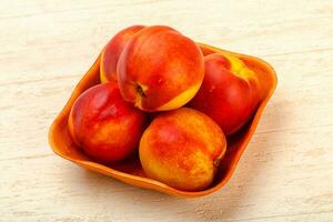 Nectarines over wooden background photo