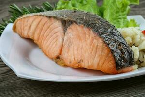 Baked salmon over wooden background photo