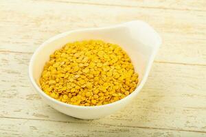 Yellow lentil over wooden background photo