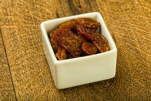 Dry Raisin over wooden background photo