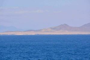 the ocean and mountains are in the distance photo