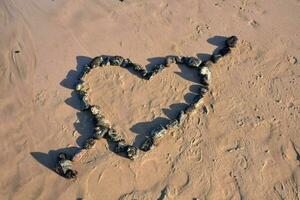 un corazón hecho de rocas en el playa foto