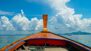 Ship Nose Front View Long tail boat at Thailand. A traditional long tail boat with decoration flowers and ribbons cruising.White cloud and clear sky. photo