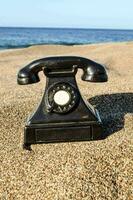 an old telephone on the beach photo