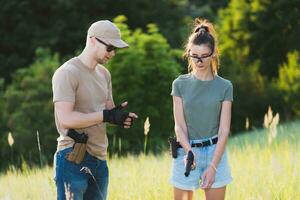 A girl learns to shoot a pistol with an instructor at the training ground photo