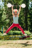 Mime jumps in the park with balloons. Clown in the air shows pantomime on the street. photo