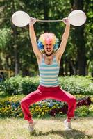 Mime performs in the park with balloons. Clown shows pantomime on the street. photo