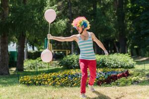 Mime performs in the park with balloons. Clown shows pantomime on the street. photo