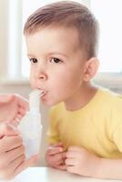 mother treats bronchitis in a child with a nebulizer photo