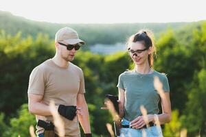 A male weapons instructor teaches a girl how to properly shoot a pistol photo