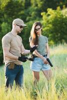 A male weapons instructor teaches a girl how to properly shoot a pistol photo