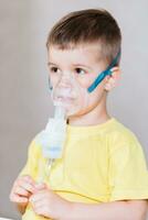 small child treats bronchitis inhaler at home photo