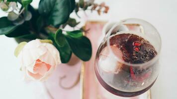 Pomegranate iced coffee. Ice coffee in a wine glass. A woman's hand pours coffee into a glass of pomegranate. photo