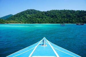 Speed boat bow while heading with beautiful water and blue sky to Moo Koh Surin island, Thailand. Speed boat bow while sailing on the blue ocean photo