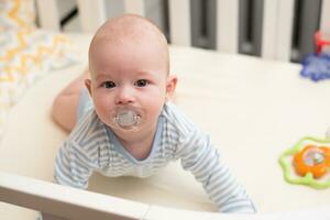 The child lies in a crib on his abdomen. photo