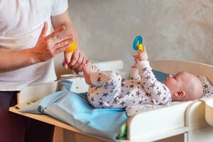 father gives his child a foot massage with a rubber ball photo