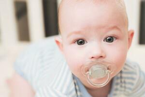 The child lies in a crib on his abdomen. photo