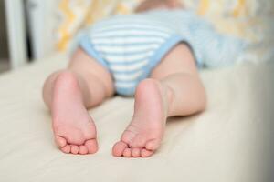 Legs of a sleeping baby in the crib. Child's foot. photo