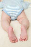 Legs of a sleeping baby in the crib. Child's foot. photo