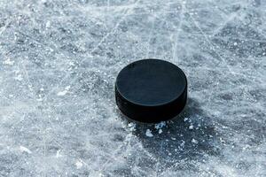 hockey puck lies on the snow close-up photo