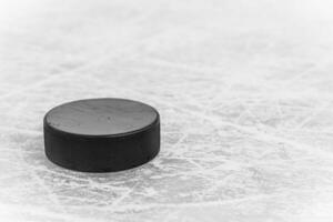 hockey puck lies on the snow close-up photo