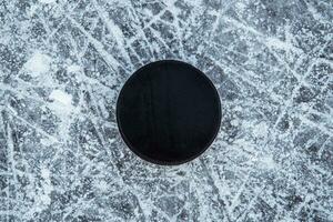 hockey puck lies on the snow close-up photo