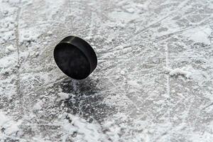 hockey puck lies on the snow close-up photo