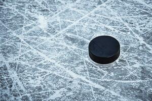 hockey puck lies on the snow close-up photo