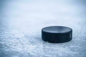 hockey puck lies on the snow close-up photo