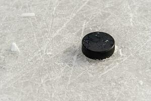 hockey puck lies on the snow close-up photo