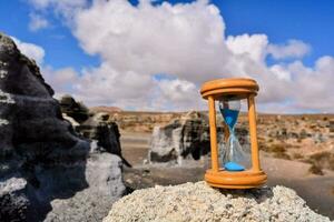 an hourglass on top of a rock in the desert photo