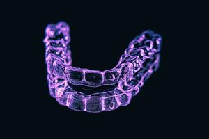 Invisible aligner teeth retainers on a black background photo