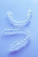 Invisible aligner teeth retainers on a blue background photo