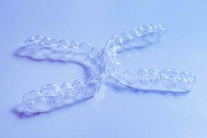 Invisible aligner teeth retainers on a blue background photo